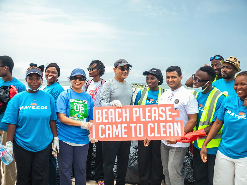 Group holding an orange sign that reads Beach Please—I Came to Clean